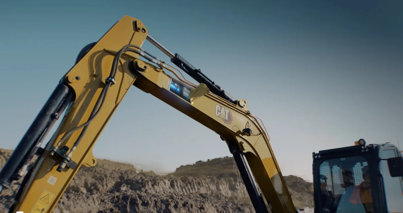 A yellow Caterpillar excavator working on a site.